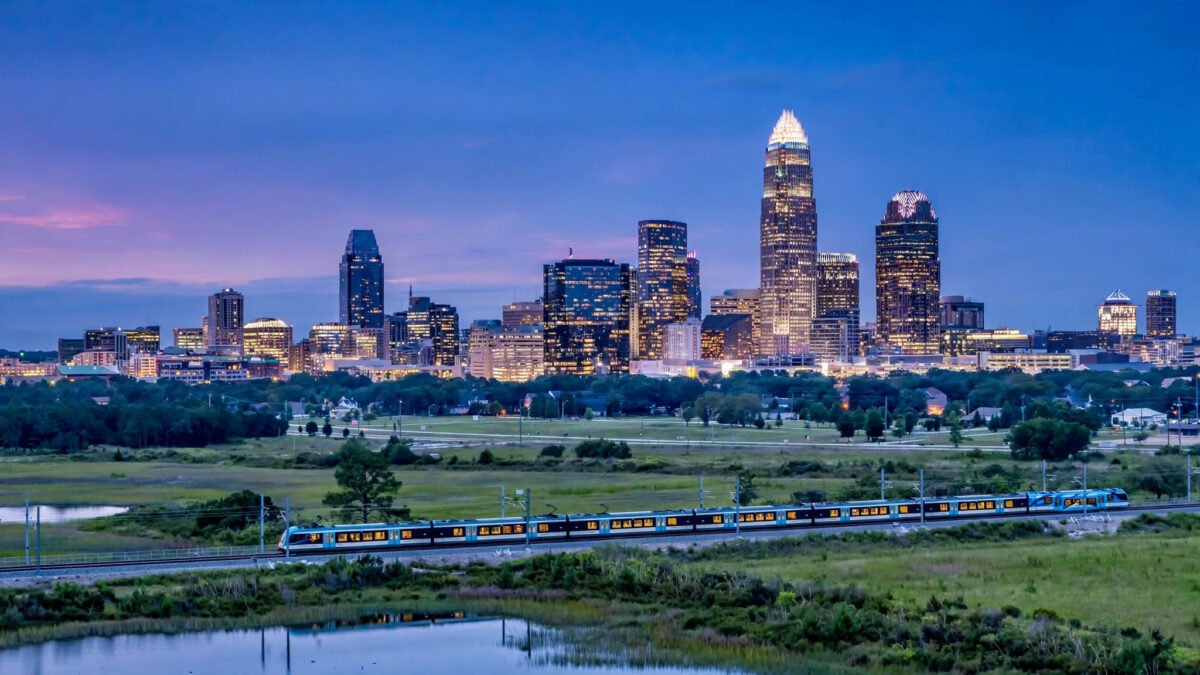 Charlotte North Carolina skyline at dusk with the light rail in the distance