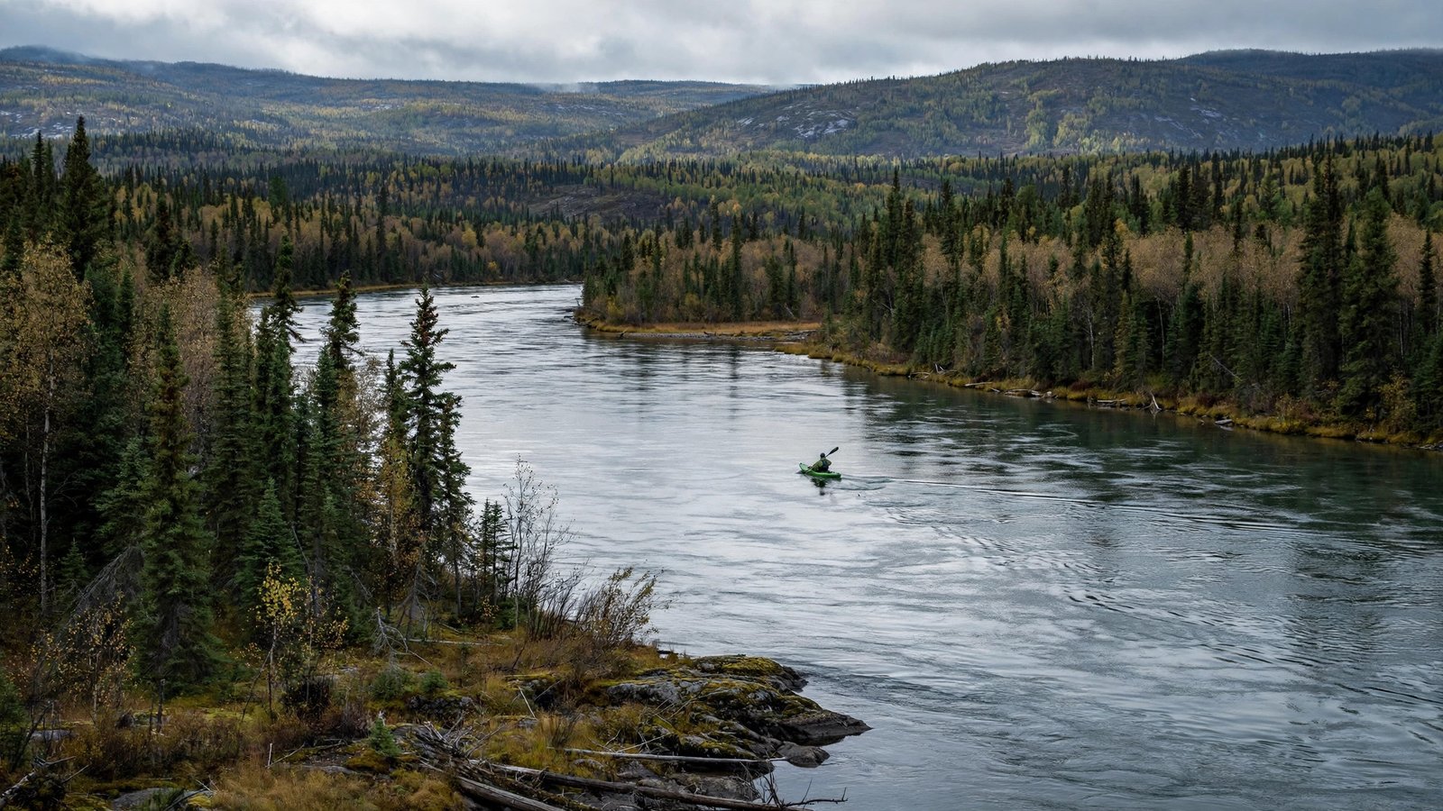 Kayaker paddling on a remote river during a long-distance endurance challenge